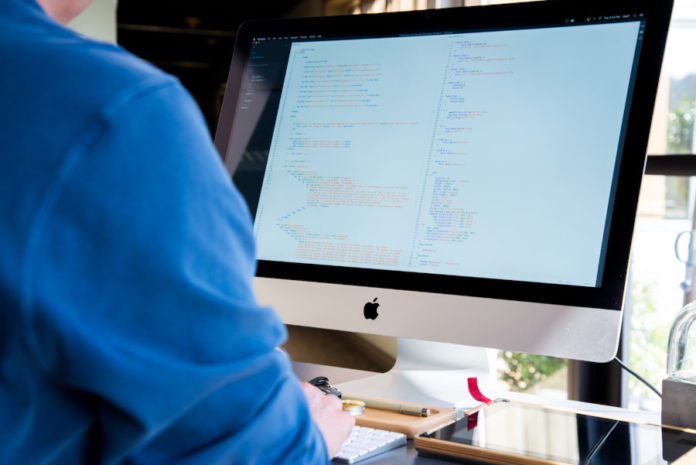 A software engineer codes on a computer.