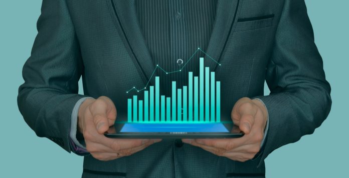 Data analysis represented through man holding up a bar graph visual.