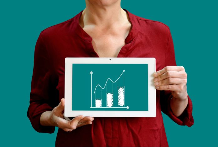 Woman holding an image of a bar graph to illustrate data visualization.