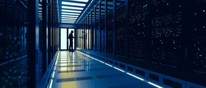 A IT employee checks on servers in a data center.