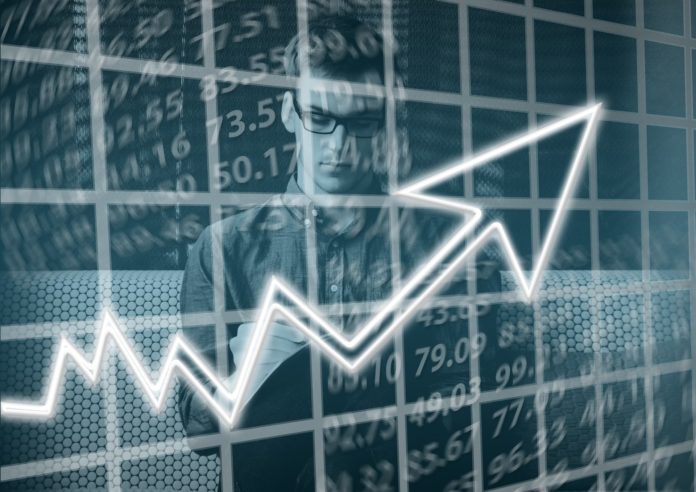 A man conducting statistical data analysis with a line graph visual.